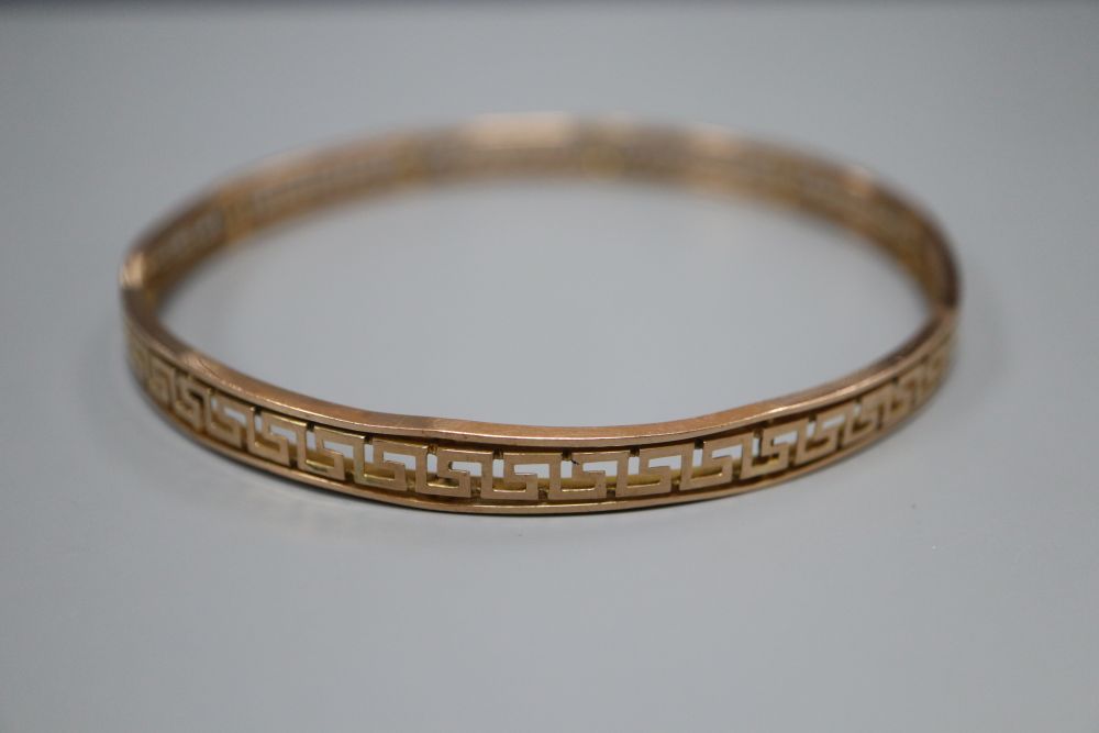 A 9ct bangle with pierced Greek key border, 12.8 grams.